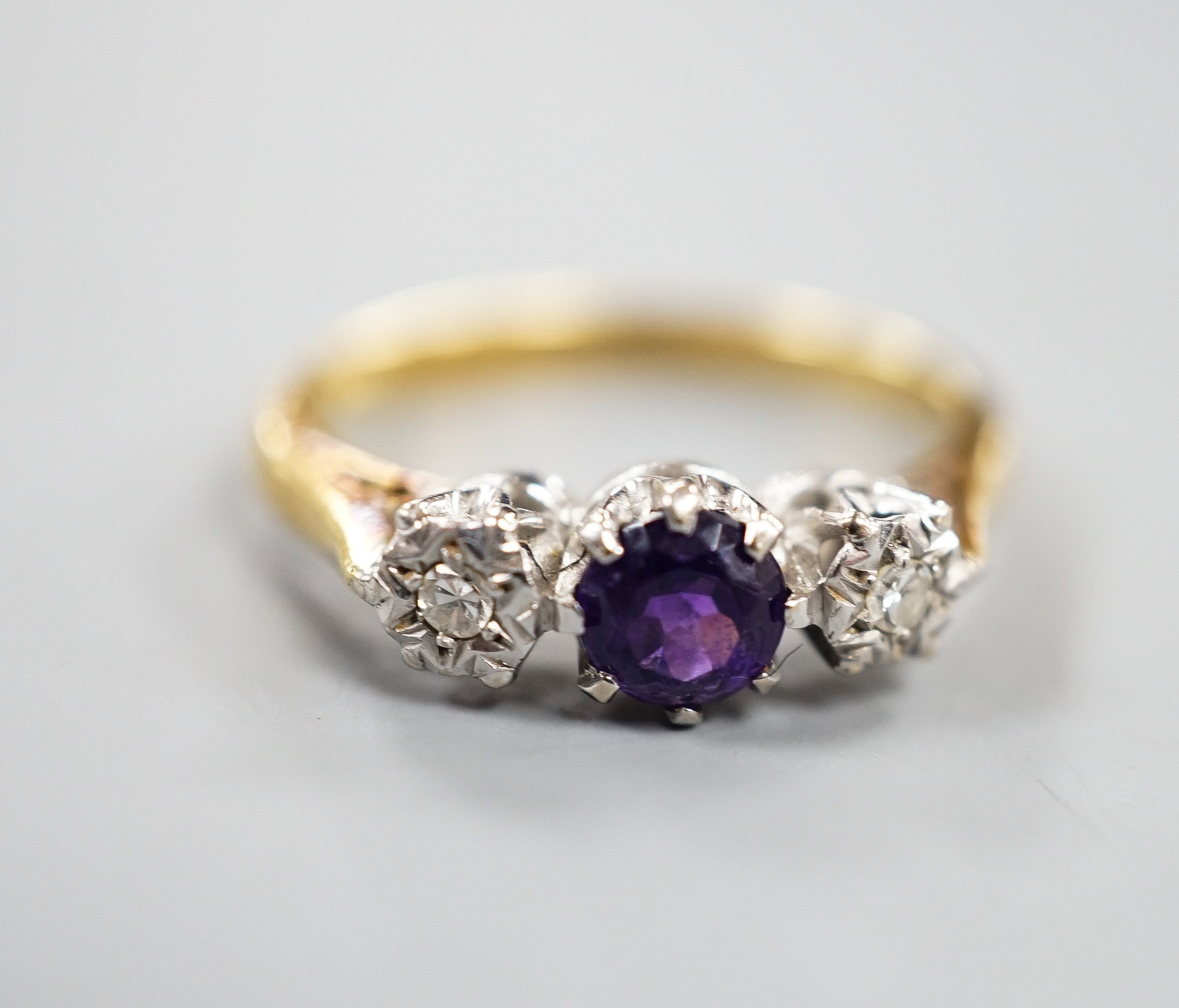 An 18ct, singe stone amethyst and illusion set two stone diamond ring, size, O/P, gross weight 3.7 grams.